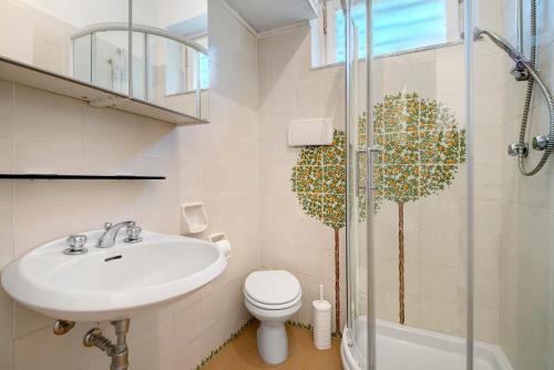 a bathroom with a sink and a toilet and a shower at Uliveto in Camogli
