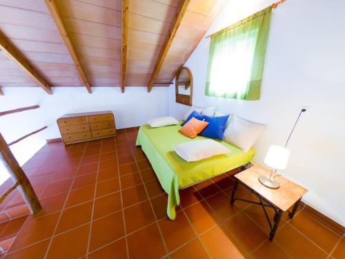 a bedroom with a green bed and a table at Casas Pepe 7 Bungalow in Los Caños de Meca