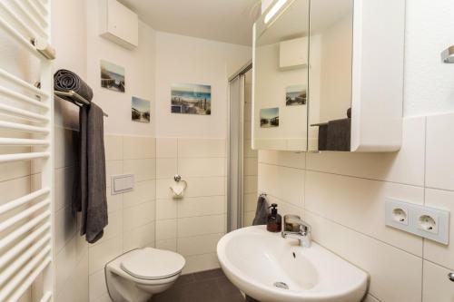 a white bathroom with a toilet and a sink at Villa Marin Wohnung 1 in Zinnowitz