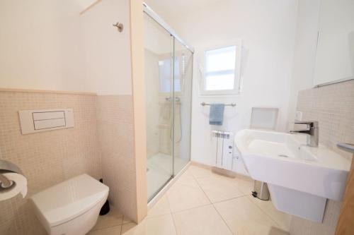 a bathroom with a toilet and a sink and a shower at Ponent in Port de Soller