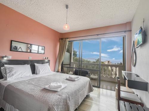 a bedroom with a bed and a large window at Andromaches sea view studio 3 in Corfu