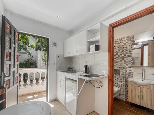 a kitchen with a sink and a toilet and a window at Andromaches sea view studio 3 in Corfu