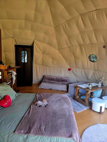 a room with two beds and a table in a yurt at La Cabane aux Chevaux in Varages