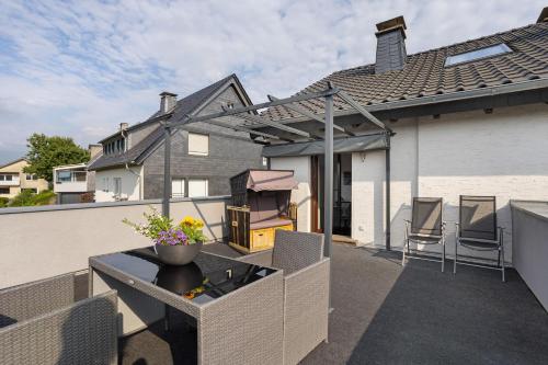a balcony with a table and chairs on a house at Ferienwohnung Zum Hasen in Meschede