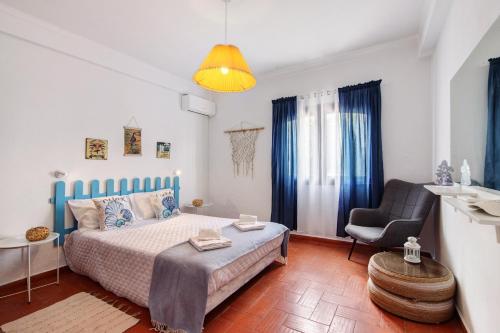 a small bedroom with a bed and a chair at Casa Amarela in Tavira