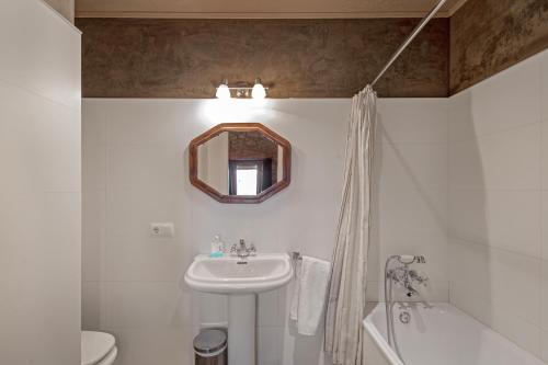a white bathroom with a sink and a mirror at El Baluard De Ferreres in Olvan