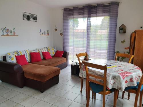 a living room with a couch and a table at Gîte de Locmousteru in Moustéru