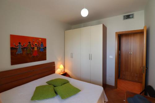 a bedroom with a bed with green pillows on it at Casa Rossana a Otranto in Otranto