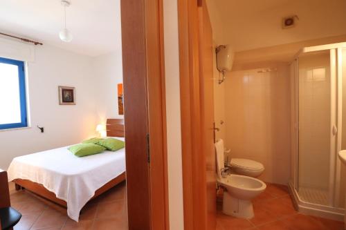a bedroom with a bed and a bathroom with a toilet at Casa Rossana a Otranto in Otranto