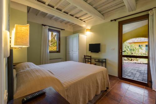a bedroom with a bed and a sliding glass door at Rosaspina - Appartamento 3 in Capalbio