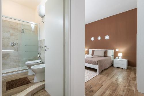 a bedroom with a bed and a toilet and a sink at Villetta Mattia in Pula