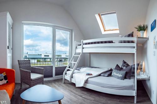 a bedroom with a bunk bed and a balcony at Fewo Ostseeflair by Seeblick Ferien in Kappeln