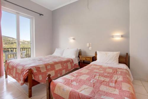 two beds in a room with a window at Dolphin Studio Sea View 10 in Keri