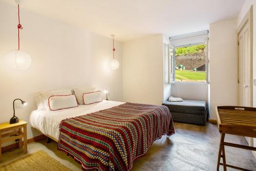 a bedroom with a bed and a window at Calheta Beach House T2 in Calheta