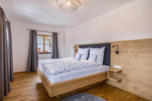 a bedroom with a large bed with a wooden headboard at Ferienwohnung Rosa in Gilching