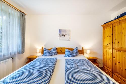 a bedroom with a bed with blue and white checked sheets at Fewo Brünnstein - Zimmer 6 in Oberaudorf
