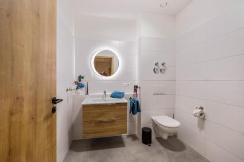 a bathroom with a sink toilet and a mirror at Ferienwohnung Rosa in Gilching