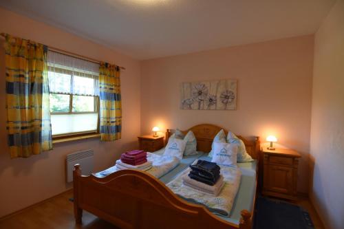 a bedroom with a bed with two lamps and a window at Haus Mövenort in Lütow
