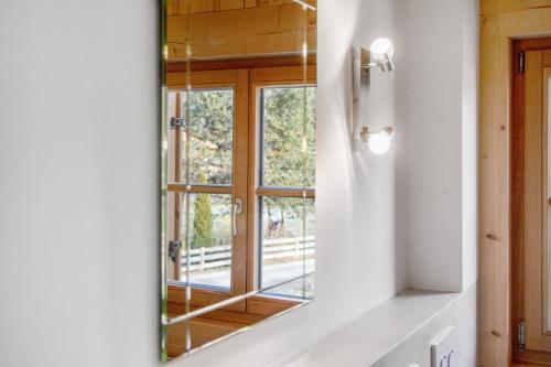 a mirror in a bathroom with a window at Ferienwohnung Uferweg in Fischbachau