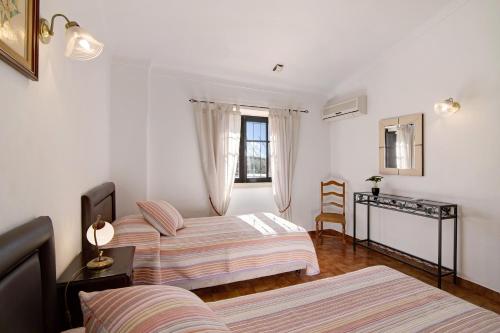 a bedroom with two beds and a window at Vila Caracol in Guia