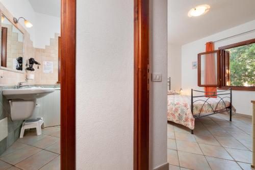 a bathroom with a sink and a bed at Villetta Bifamiliare 2 in San Teodoro