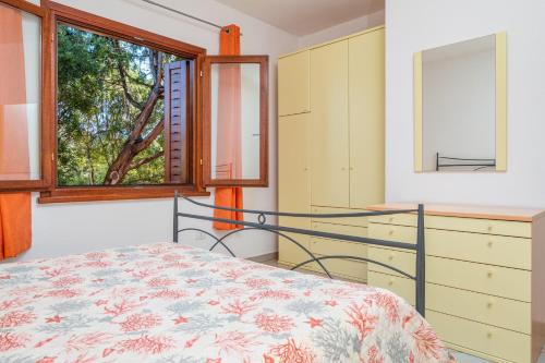 a bedroom with a bed and a window at Villetta Bifamiliare 2 in San Teodoro