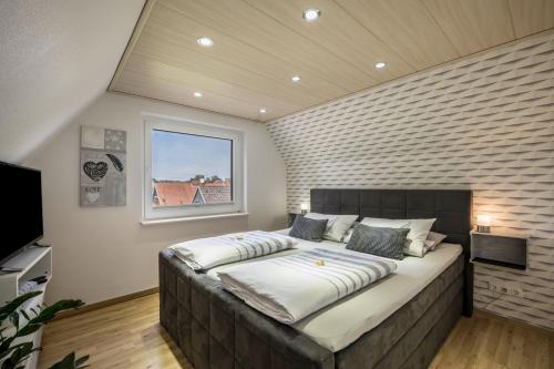 a large bed in a room with a brick wall at Ankerplatz Maria Ratekau in Ratekau