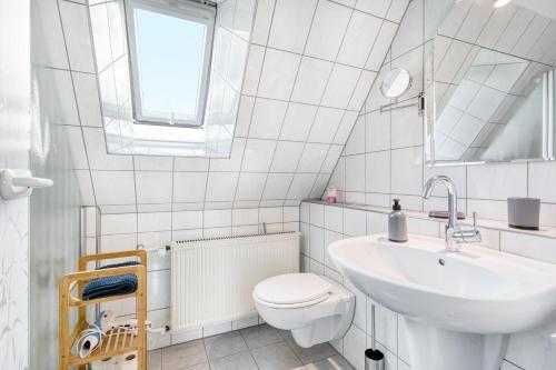 a white bathroom with a sink and a toilet at Ferienwohnung Langenhorst in Raesfeld