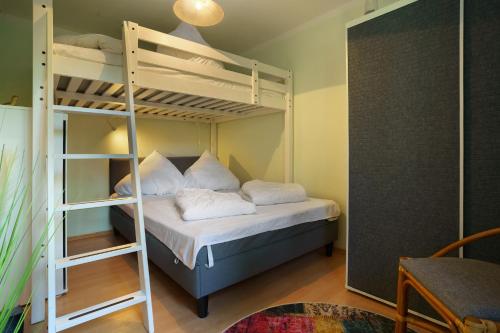 a bedroom with a bunk bed with white pillows at Bungalow Karsten in Kamminke
