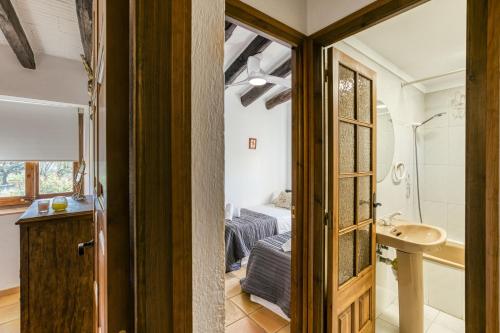 a bathroom with a bed and a sink in a room at Can Cortada in Cantallops