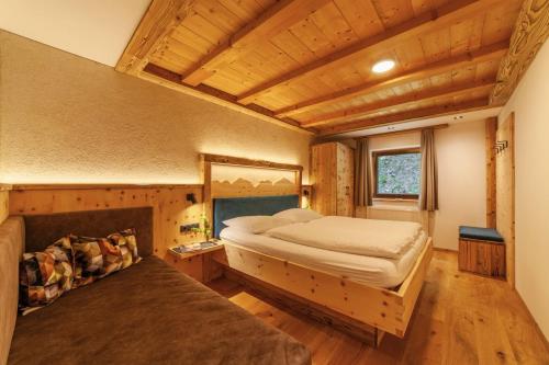a bedroom with a bed and a couch in a room at Mühlanderhof Apt Piz Lad in Resia