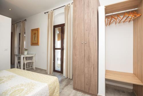 a bedroom with a bed and a wooden closet at Apartamento Geranio in Vejer de la Frontera
