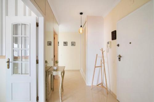 a hallway with a white door and a table at Pérola do Atlântico By the Sea in Quarteira