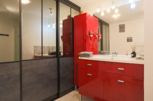a bathroom with a red cabinet and a sink at Gîte Les Galets Blancs in Trébeurden