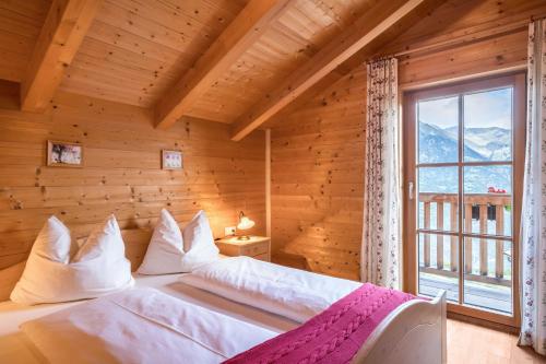 a bedroom with a bed in a wooden room with a window at Thaler-hof Ferienhaus Fichtnhittl in Lagundo