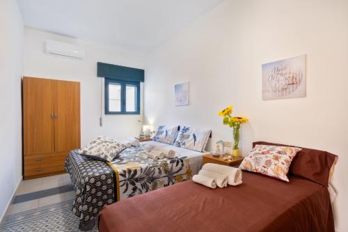 a living room with two beds and a window at Malva House in Villa Con Piscina in Torre Lapillo