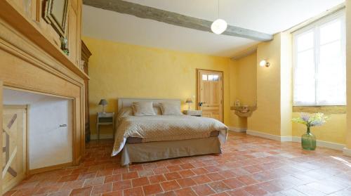 a bedroom with a bed in a room with yellow walls at Le Guitou de Monlezun in Monlezun