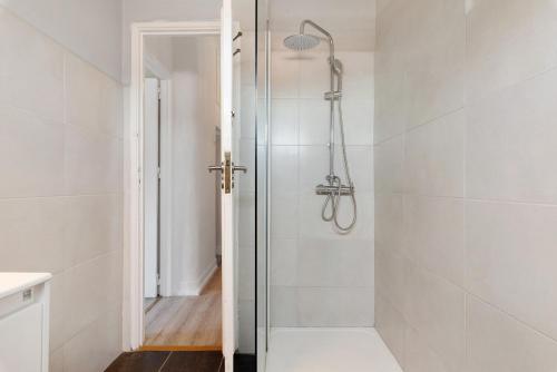 a shower with a glass door in a bathroom at Bisa's house in Estoril