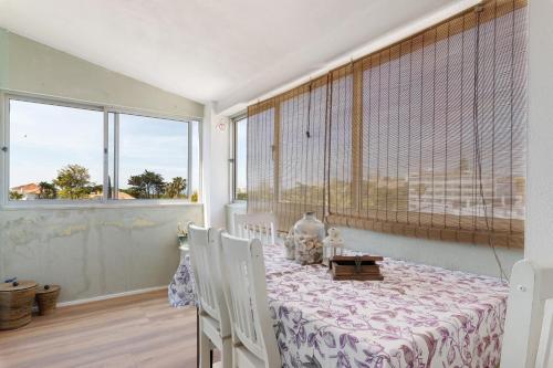 a dining room with a table and chairs and a window at Bisa's house in Estoril