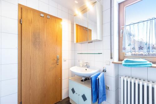 a white bathroom with a sink and a mirror at Ferienwohnung Hewenpanorama 1 in Engen