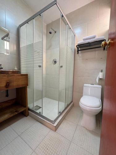 a bathroom with a glass shower and a toilet at Casa Bella Vizcaína in Mineral de Pozos