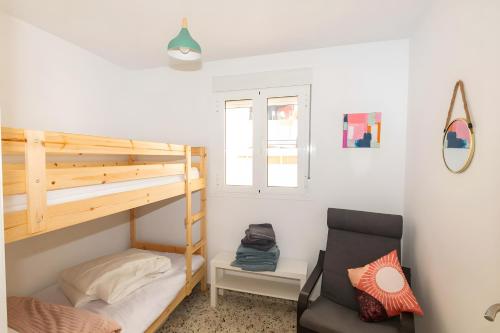 a small room with a bunk bed and a chair at Casa de Arte in Torrox