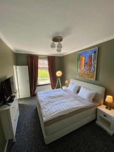 a bedroom with a white bed and a window at Stylischer Altbau im Zentrum in Kiel