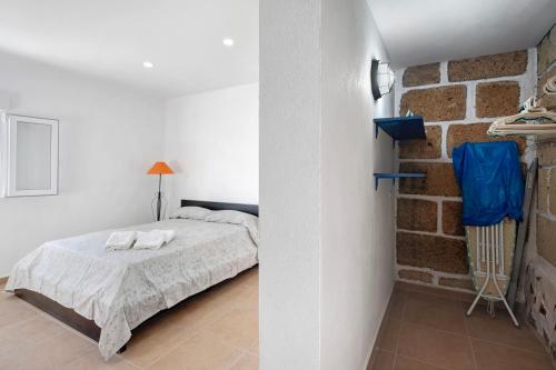 a bedroom with a bed and a brick wall at Finca Eva in Granadilla de Abona