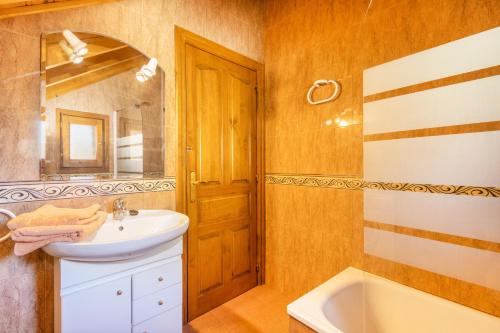 a bathroom with a sink and a tub and a mirror at La Golfa in Durro