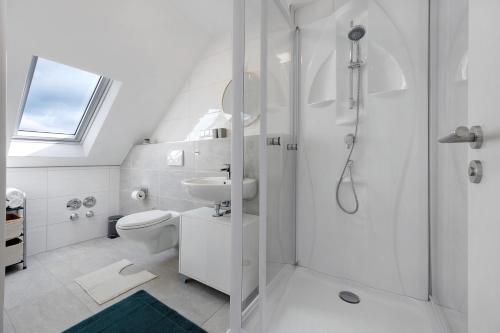 a white bathroom with a shower and a toilet at Ferienwohnung 2 in Bad Salzuflen