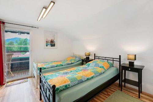 two beds in a room with a window at Haus Ruheplatzerl in Ruhpolding