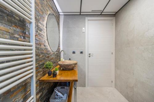 a bathroom with a sink and a brick wall at El Cierzo de Sediles in Sediles