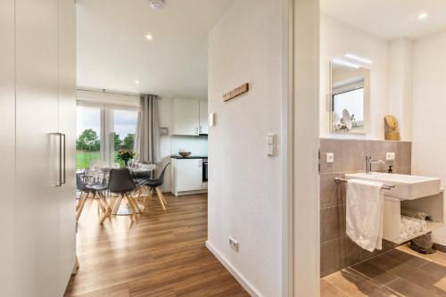 a kitchen and living room with a sink and a table at Fewo Parkside S3 - 8Min Legoland in Günzburg