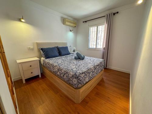 a bedroom with a bed with blue pillows and a window at Casa Blanca in Torrox Costa